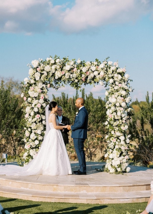 3 2 wedding ceremony under large white floral arch