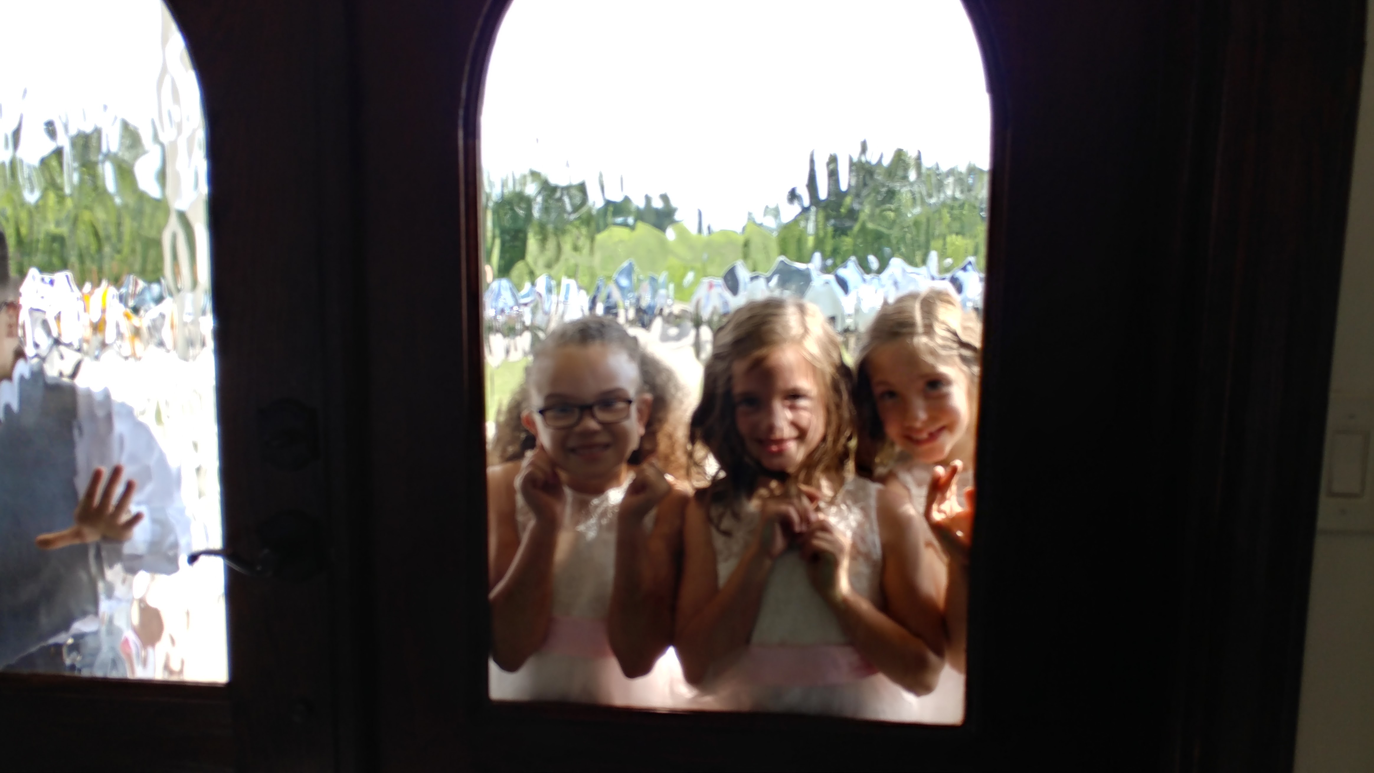 flower girls looking through venue window